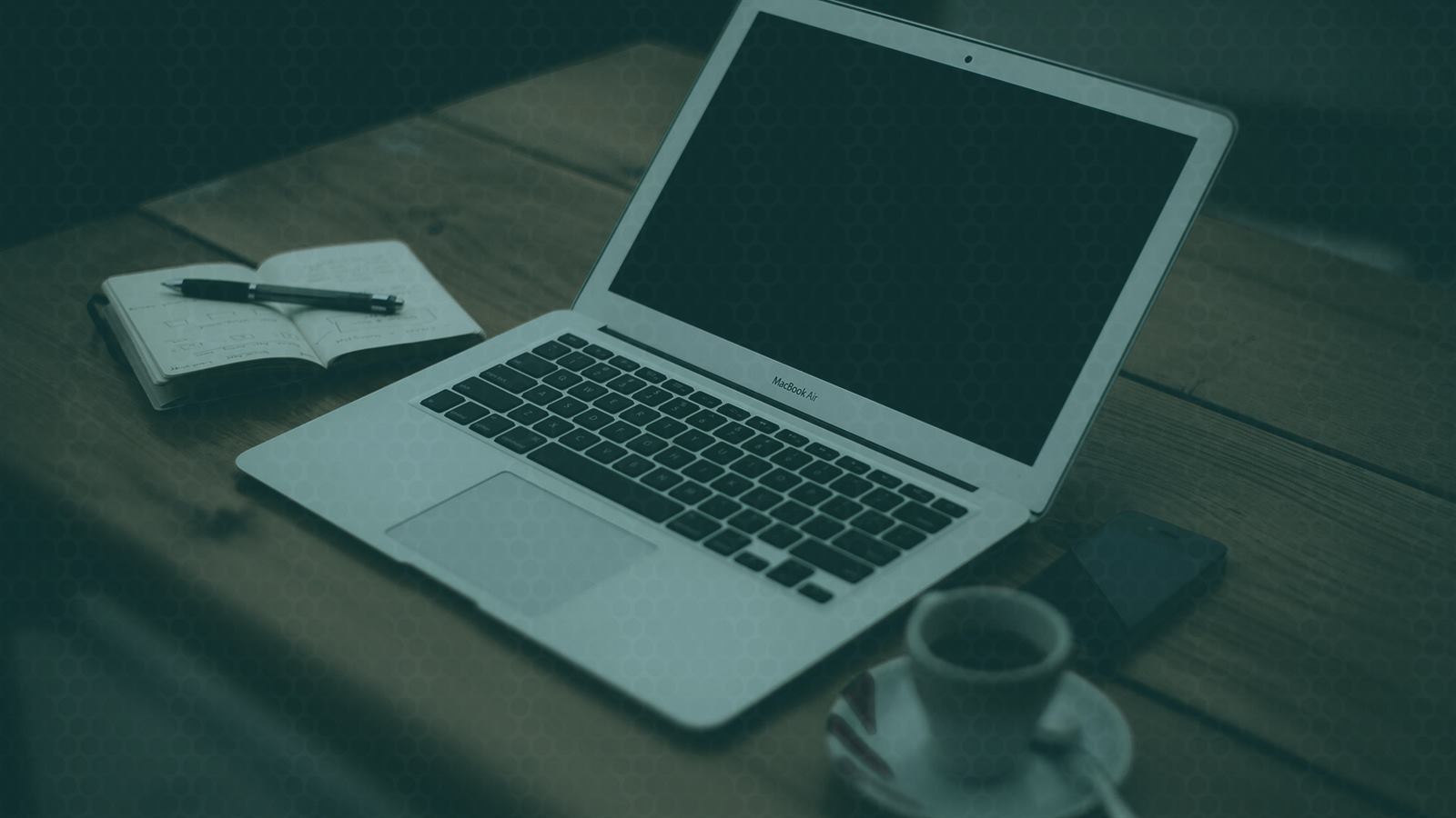 A laptop and notebook on a desk